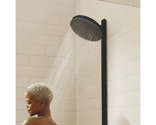 Duschhuvud med kvinna som duschar i badrummet.