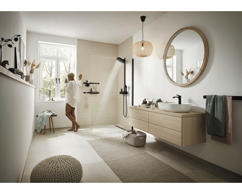 Ljust badrum med dusch, handfat, spegel och dekorationer för en modern atmosfär.