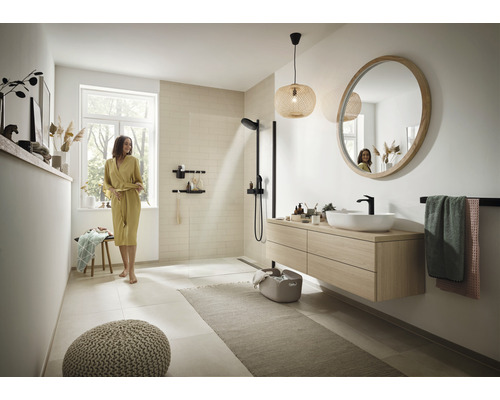 Ljust badrum med dusch, tvättställ med spegel, handdukshängare och sittplats