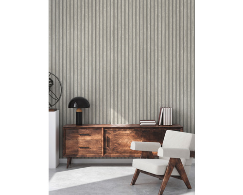 Vardagsrum med räfflad tapet, byrå och fåtölj