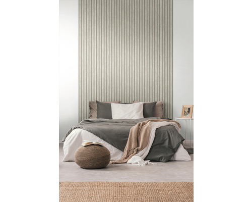 Sovrum med säng framför en vägg med ribbad tapet