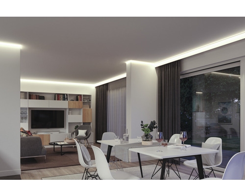 Vardagsrum med indirekt takbelysning, matbord och bokhylla