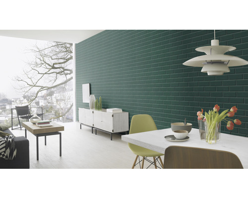 Vardagsrum med grön tegelvägg, matbord och fönster