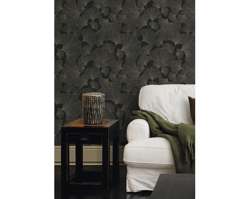Vardagsrum med svart tapet med ginkgobladmönster, sidobord och soffa