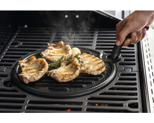 Kött, rosmarin och vitlök på en grillplatta av gjutjärn