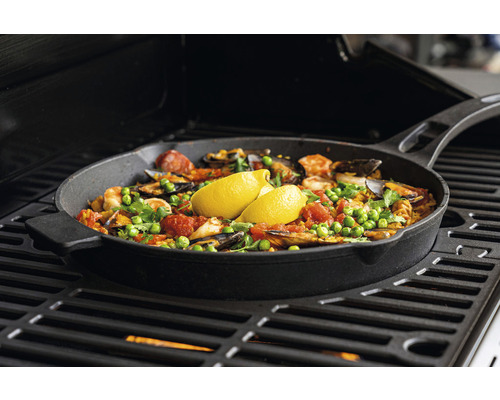 Paella i en järnpanna tillagad på en grill