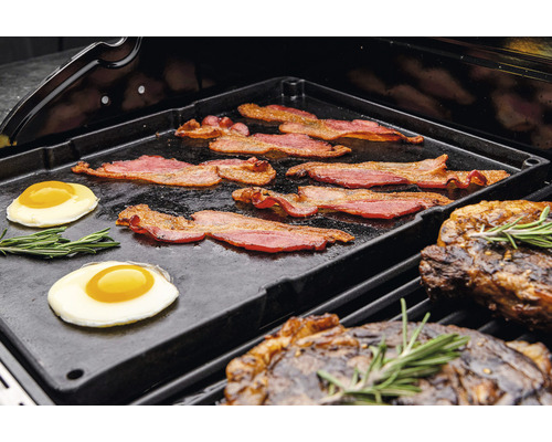 Bacon, stekta ägg och biffar på en grillplatta