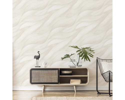 Vardagsrum med mönstrad tapet, byrå och dekorationer.