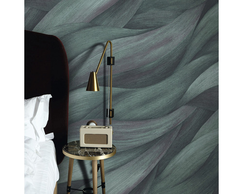 Sovrum med mönstrad tapet, sängbord och lampa