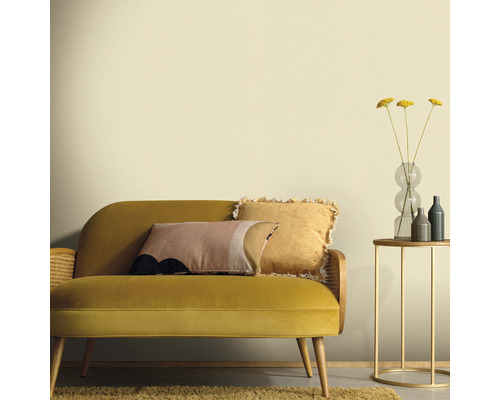 Vardagsrum med gul soffa, kuddar, sidobord och vas