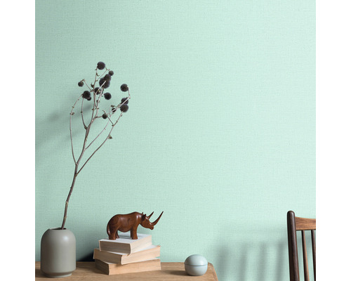 Dekorativ väggdekoration med vas, dekoration och böcker på ett bord framför en vägg