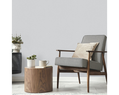 Ljust rum med fåtölj, sidobord och krukväxter