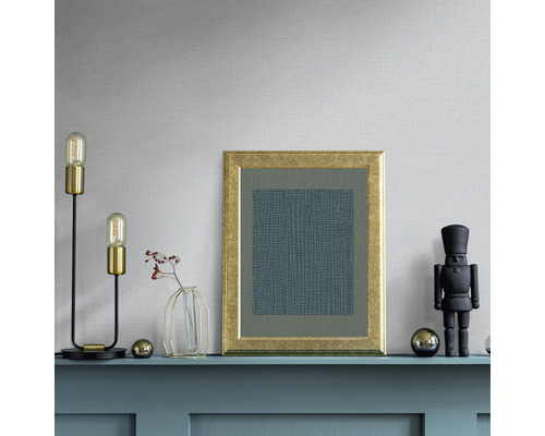 Dekorativt arrangemang på en hylla med lampa, bild, vas och nötknäppare