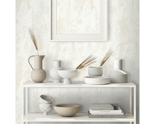 Hylla med dekorativa föremål framför en mönstrad tapet