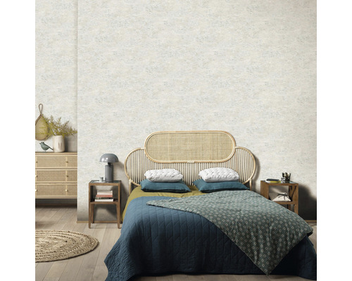 Sovrum med rotting säng, sängbord och mönstrad tapet för en lugn atmosfär.