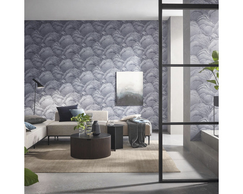 Vardagsrum med mönstrad tapet, soffa, bord och dekorationer för en modern inredning.