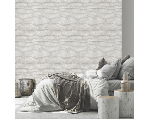 Sovrum med säng framför en ljus tapet med vågmönster