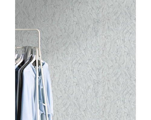 Närbild av en strukturtapet med klädställning och kläder i rummet