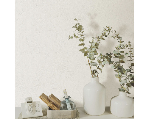 Närbild av en vit strukturtapet med telefon och dekorativa vaser