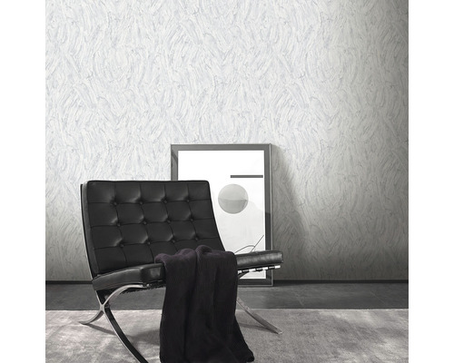 Vardagsrumsscen med mönstrad tapet, fåtölj och bild