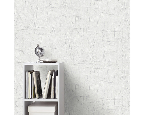 Scen med en vit tapet med repmönster och en vit hylla med dekorationer