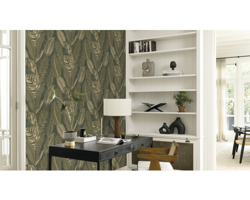 Dekorativt vardagsrum med bladmotiv tapet, skrivbord och bokhylla