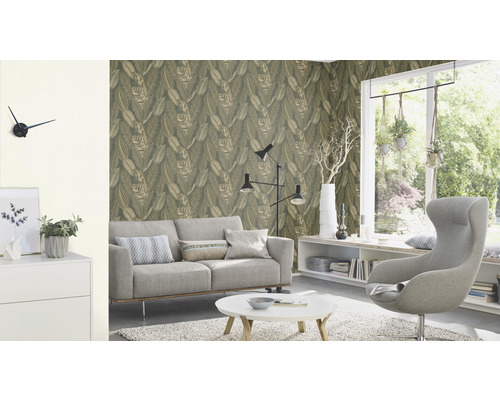 Vardagsrum med soffa, fåtölj och tapet med bladmönster