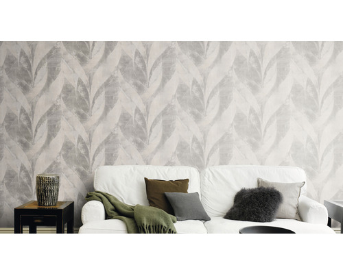 Vardagsrum med tapet med bladmönster och vit soffa