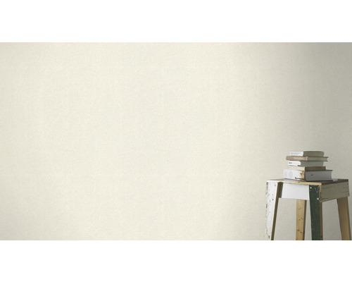 Närbild av en väggbeklädnad med ett subtilt mönster bredvid en stapel böcker på en pall