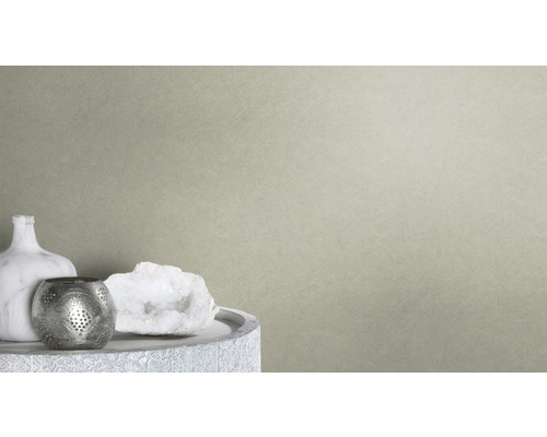 Närbild av en beige non-woven tapet med fin struktur