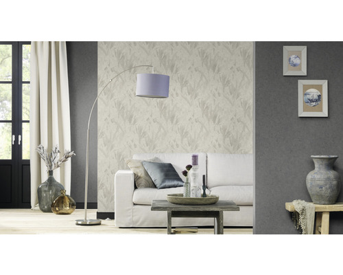Vardagsrum med soffa, lampa, bord och dekorativ tapet
