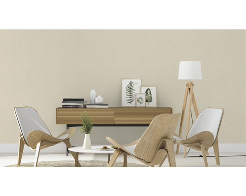 Vardagsrum med två trästolar, en byrå, ett bord och en golvlampa.