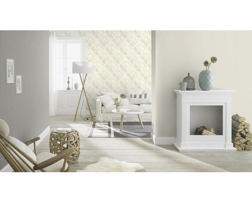 Vardagsrum med soffa, lampa, öppen spis och mönstrad tapet