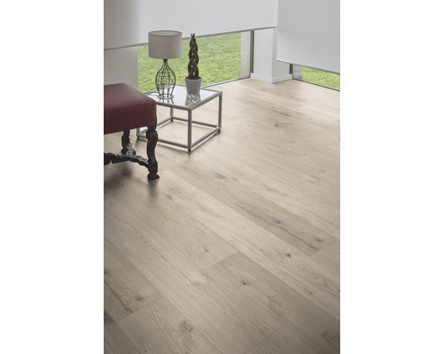 Ljust rum med trägolv, sidobord och sittpuff.