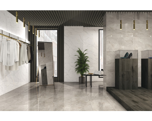 Ljust rum med marmorplattor, kläder, spegel och skor i montrar