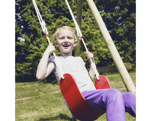 Flicka svingar på en röd gunga