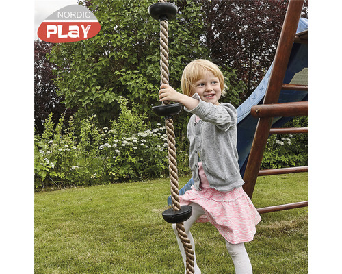 Flicka klättrar i ett klätterrep med tallrikar i trädgården.