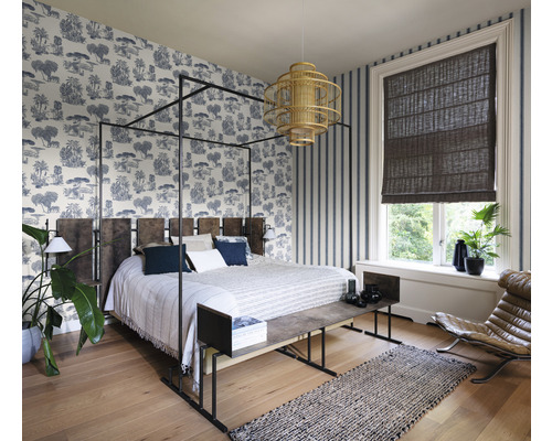 Sovrum med himmelssäng, mönstrade tapeter och fönster med rullgardin