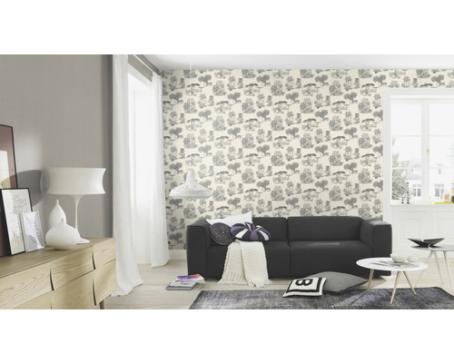 Ljust vardagsrum med mönstrad tapet, soffa och möbler.
