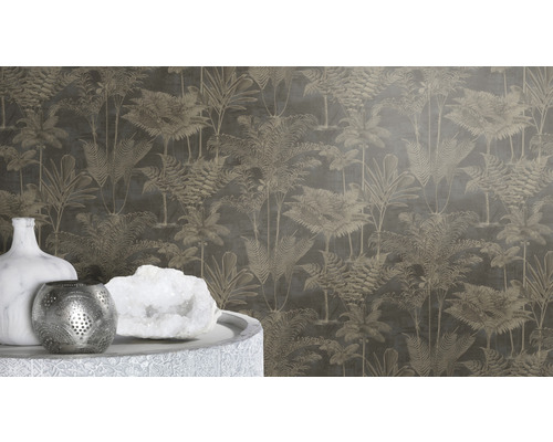 Närbild av en vägg med djungeltapet med palmträdsmönster, plus en vas, en värmeljushållare och en vit kristall på ett bord