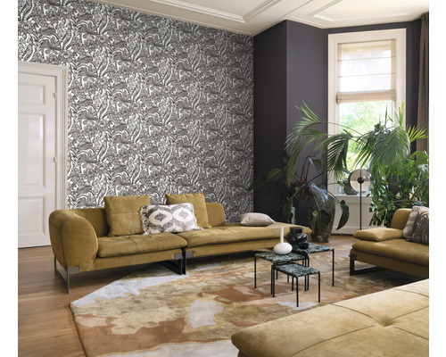 Vardagsrum med mönstrad tapet, soffa och matta