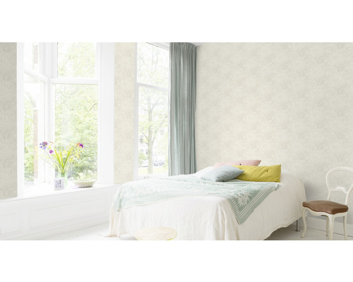 Ljust sovrum med mönstrad tapet, säng och fönster.