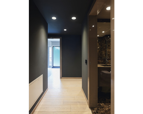 Interiörbild av en hall med infällda spotlights och angränsande badrum