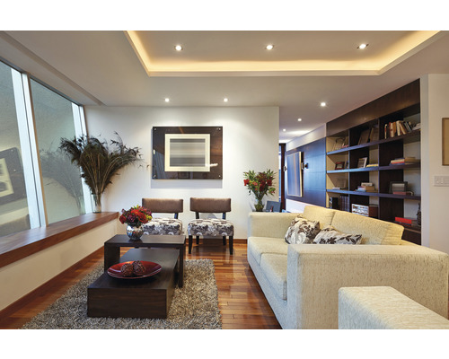 Vardagsrum med soffa, fåtöljer, soffbord och hyllor