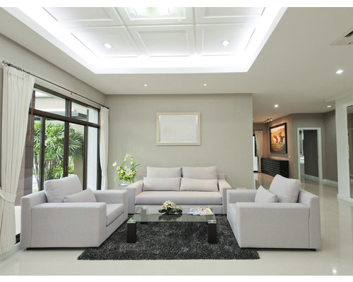 Ljust vardagsrum med soffa, fåtölj och matta