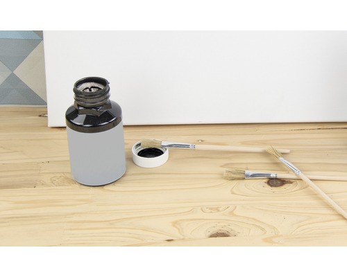 Färghink med penslar på träbakgrund