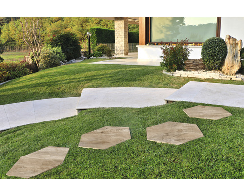 Trädgårdslandskap med gräsmatta och gångväg av stenplattor