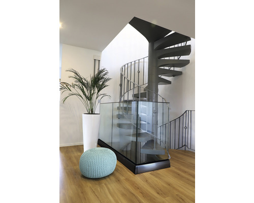 Miljöbild med spiraltrappa, krukväxt och sittdyna