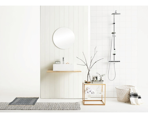 Ljust badrum med handfat, spegel, dusch och dekorativa element för en modern atmosfär