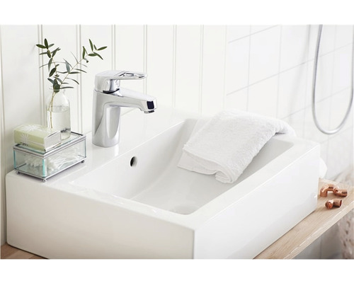 Badrumshandfat med blandare, handduk, växt och dekoration